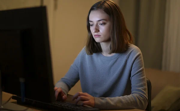 грустная девушка сидит за компьютером
